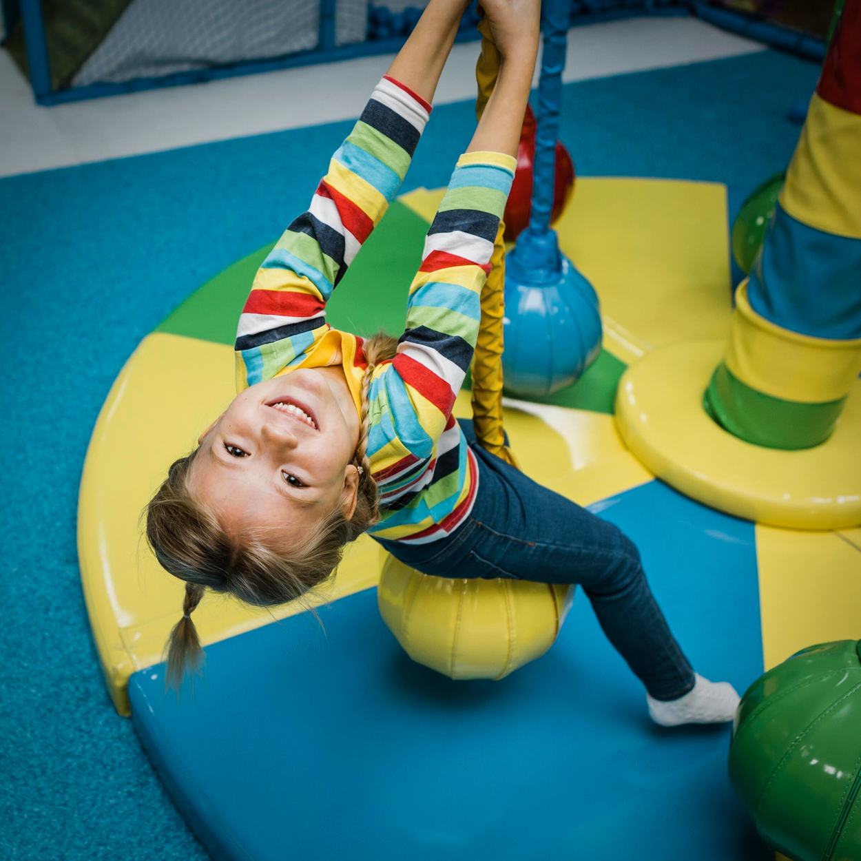 A little girl swinging on an indoor swing