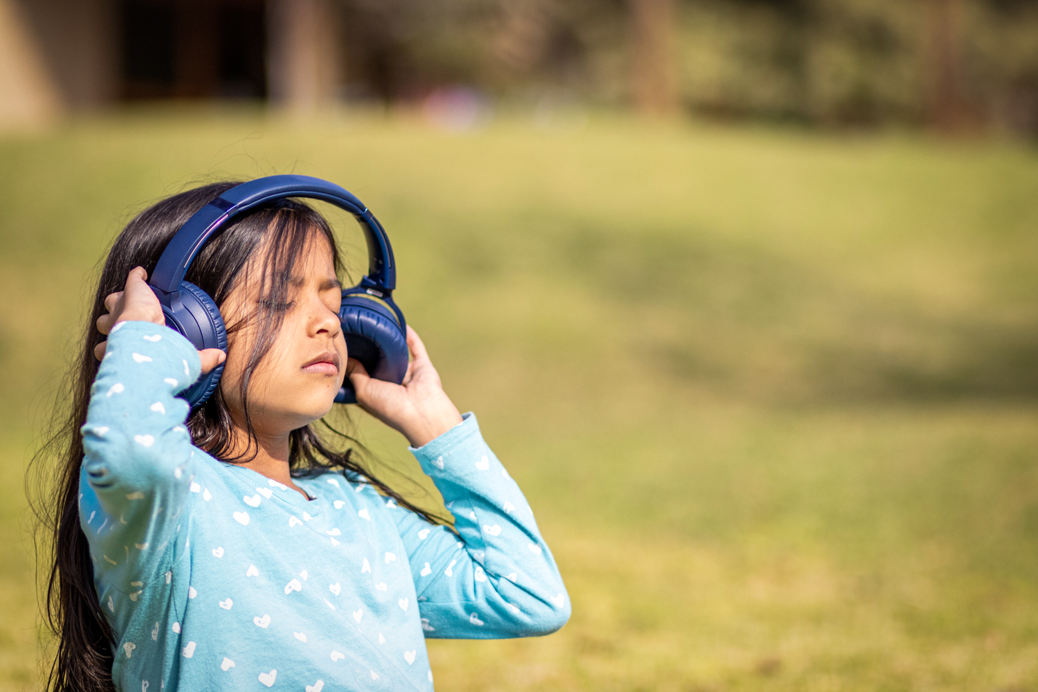 A little girl wearing noise cancelation headphones due to Auditory Sensory Processing disorder