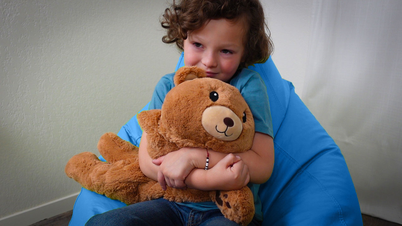 A little boy hugging a weighted 