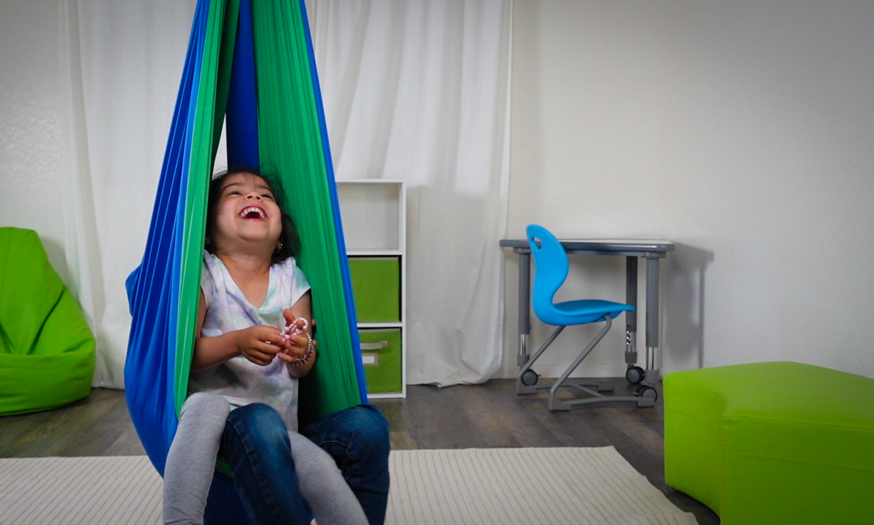 A little girl laughing and interacting with her sibling