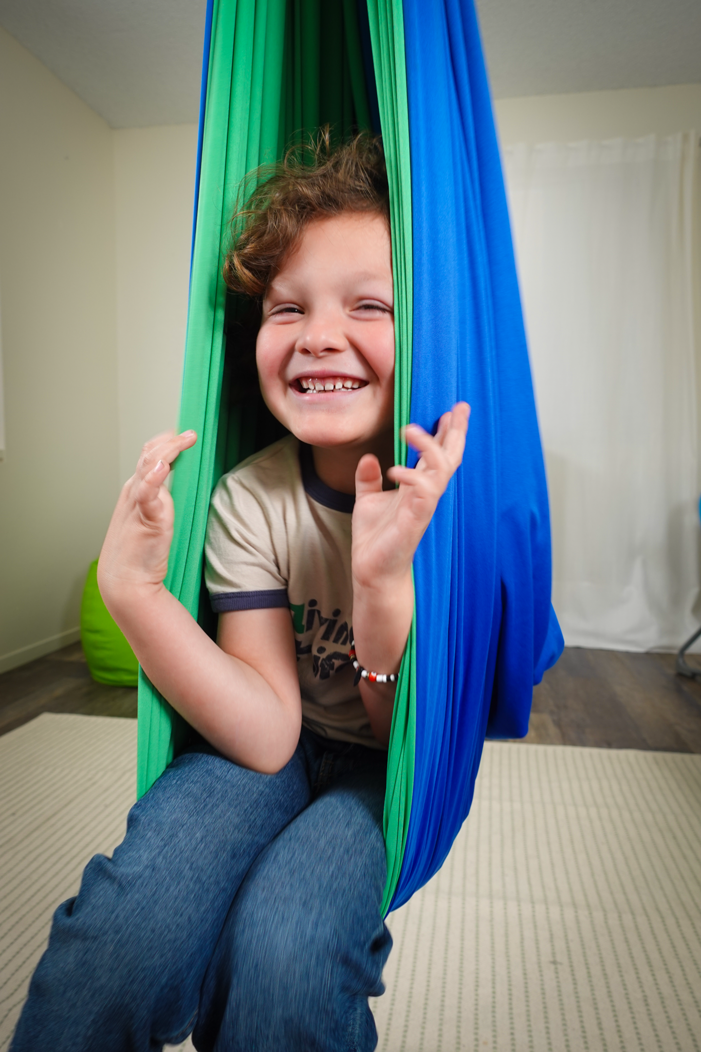 A picture showing a little boy on a sensory swing