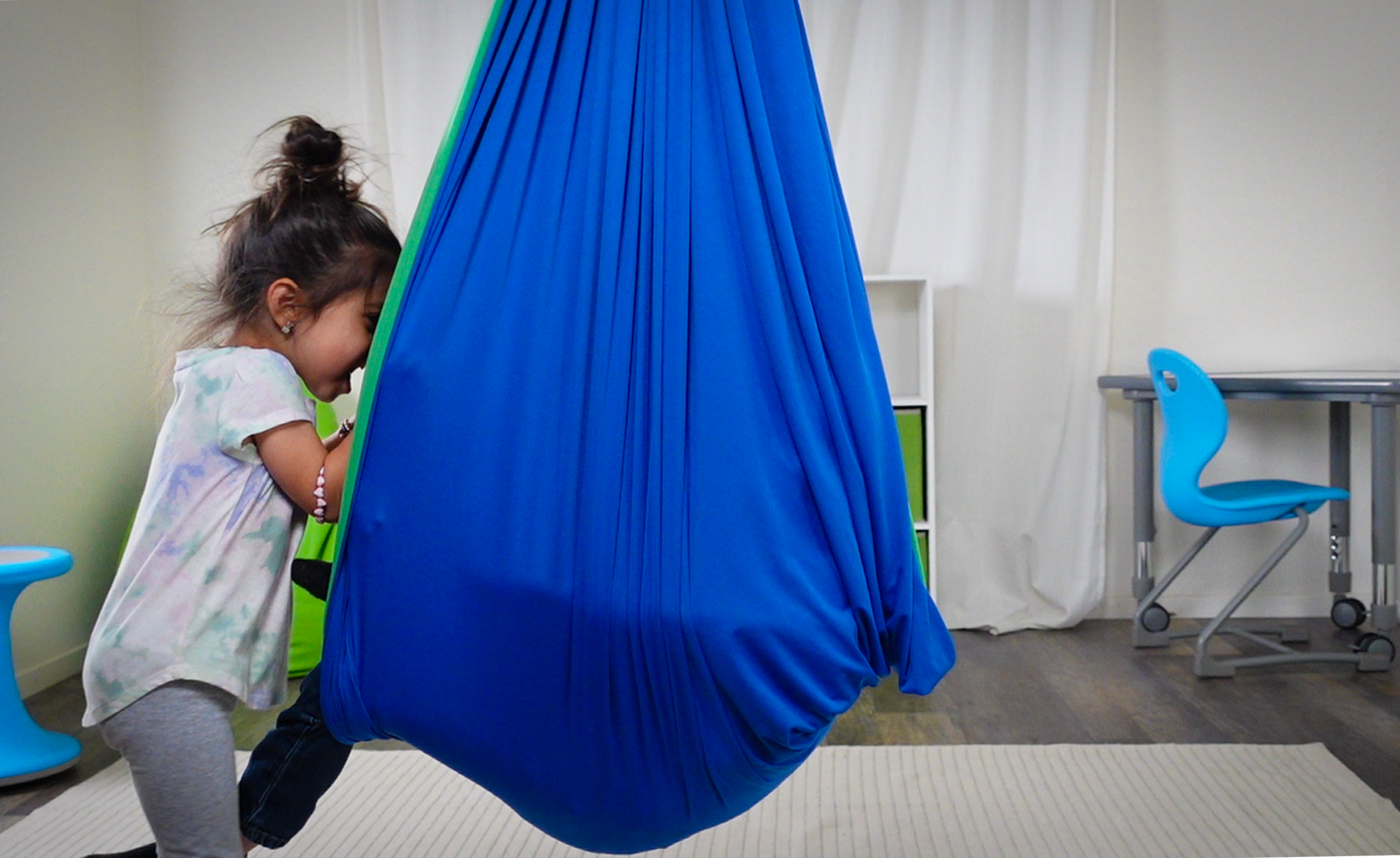 Two sibling in a Sensory Swing